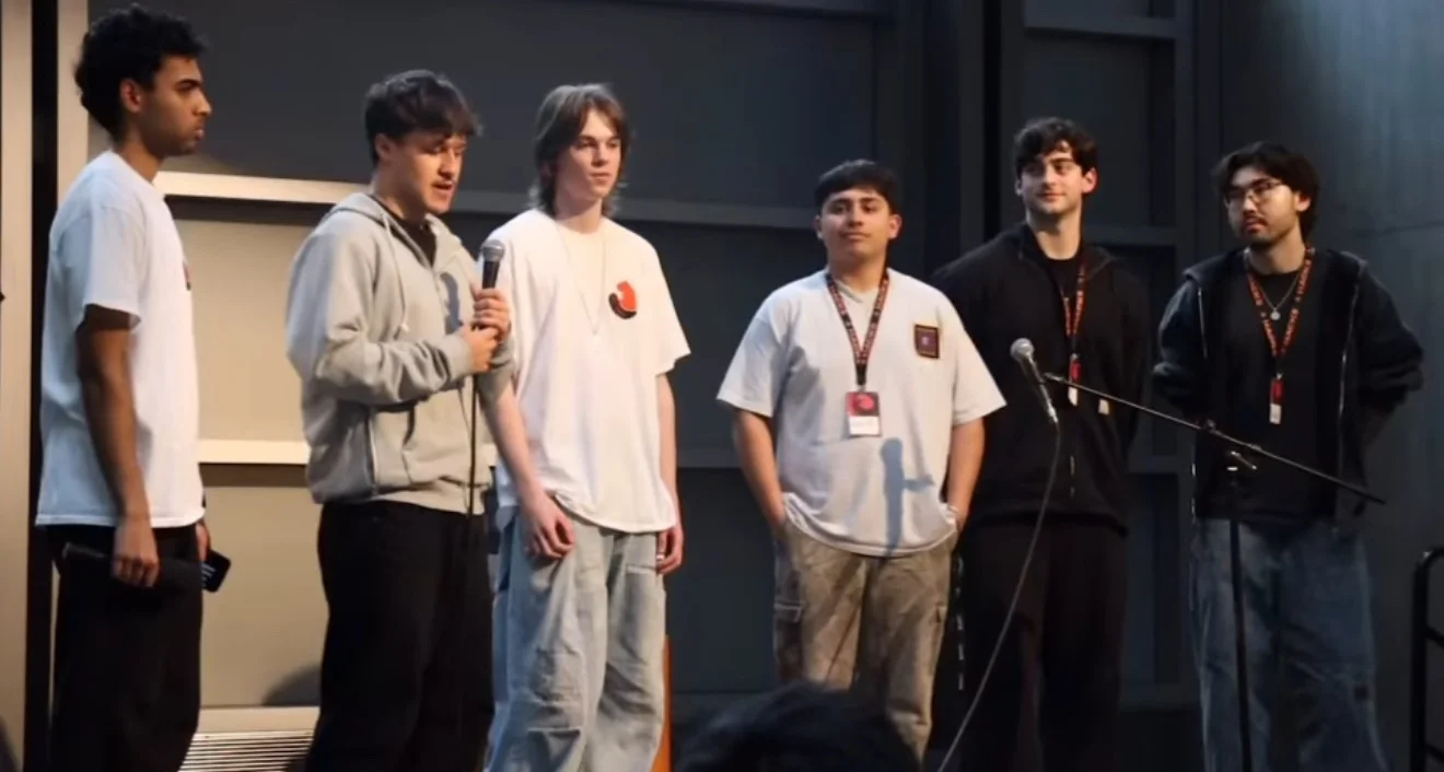A team presenting on stage at a hackathon