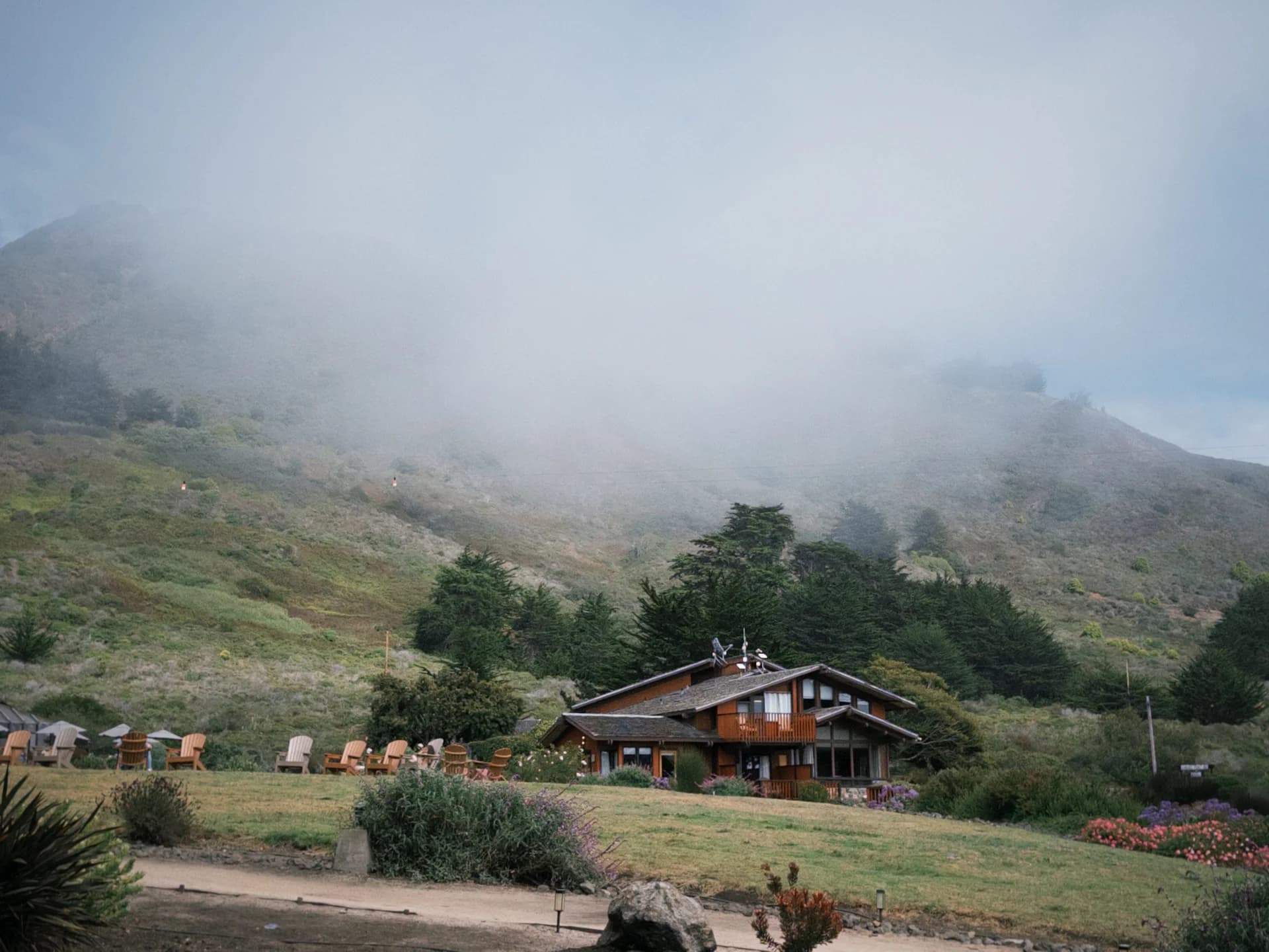 A lodge beneath fog-covered hills